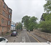 The school faces off against a red sandstone tenement opposite