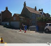 The cottage occupies a prominent corner plot in the coastal town