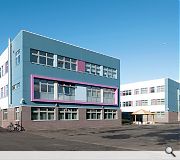 The school is clad in blue and grey brick, render and metal cladding