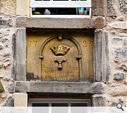 A carved panel in one of the central bays between the first and second floors which displays the emblem of the cordiner