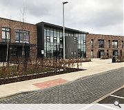 Brick, curtain walling, slate and black cladding panels define the front elevations