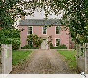 Reddish-pink stonework references the front facade
