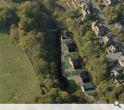 The rare patch of level ground sits at the foot of an embankment downriver from a weir