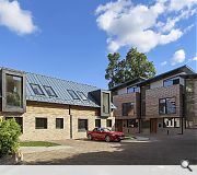 Projecting zinc and larch boxes address a shared interior courtyard