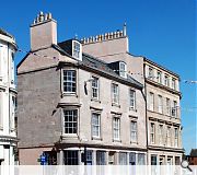 A new painted metal balustrade and balconies, cast iron downpipes and gutters, a new shop entrance and painted metal gates have been introduced